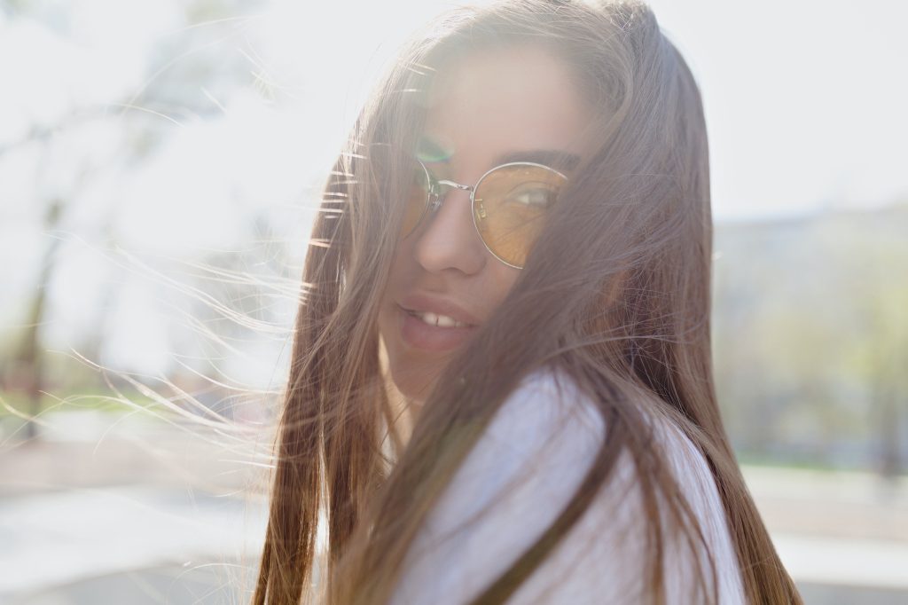 Close up portrait of a sensitive romantic girl with brown hair wearing yellow spectaculars