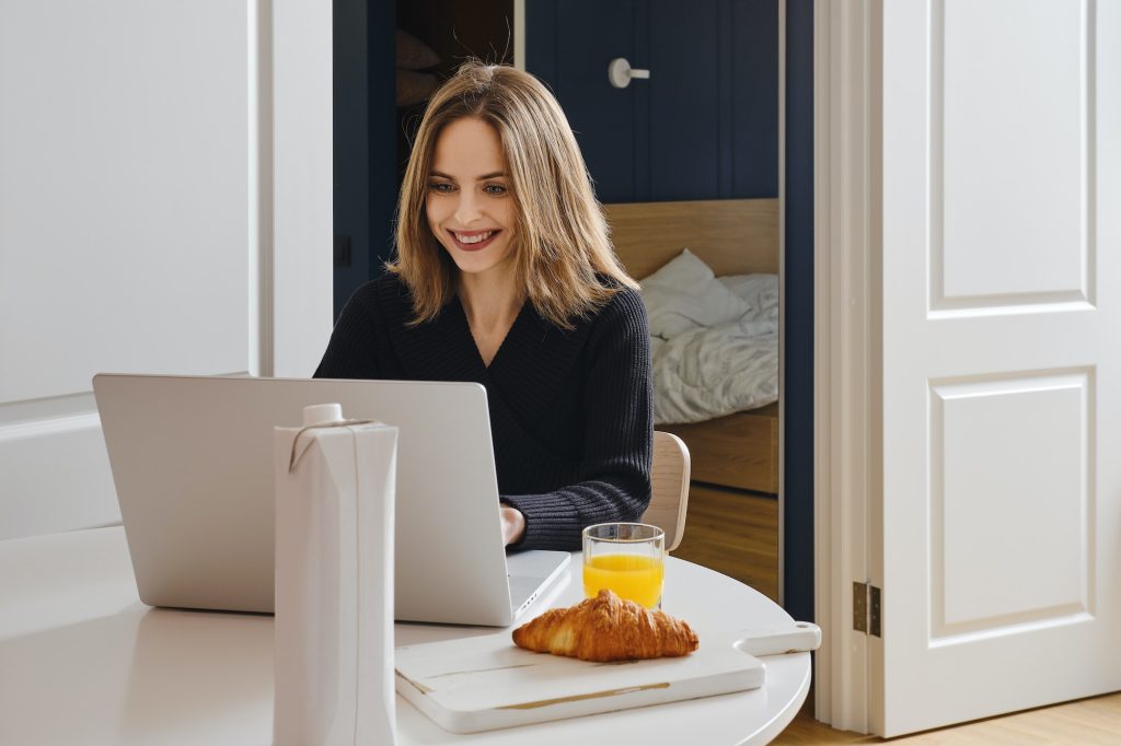 Happy woman chatting online from home